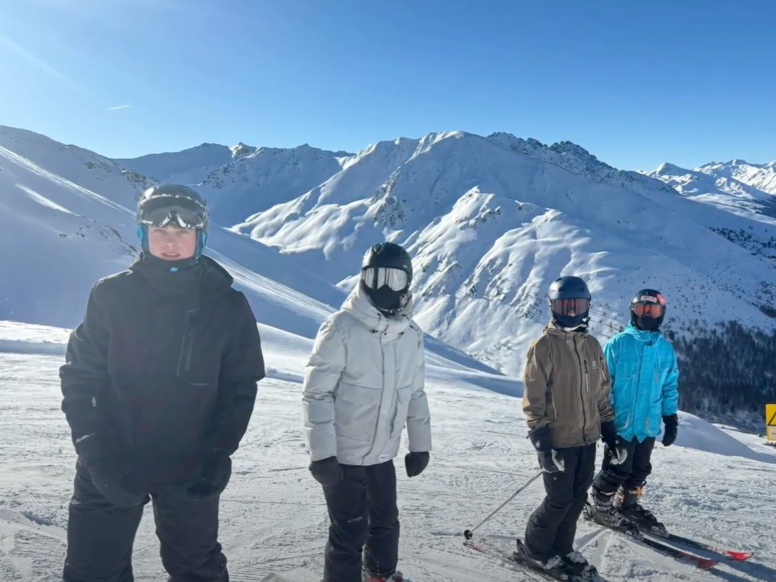 Fire elever smiler til kameraet på skitur med folkeskole